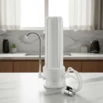 Filtro purificador de agua sobre mesada con carcasa plástica y cartucho de carbón activado, ideal para uso doméstico.